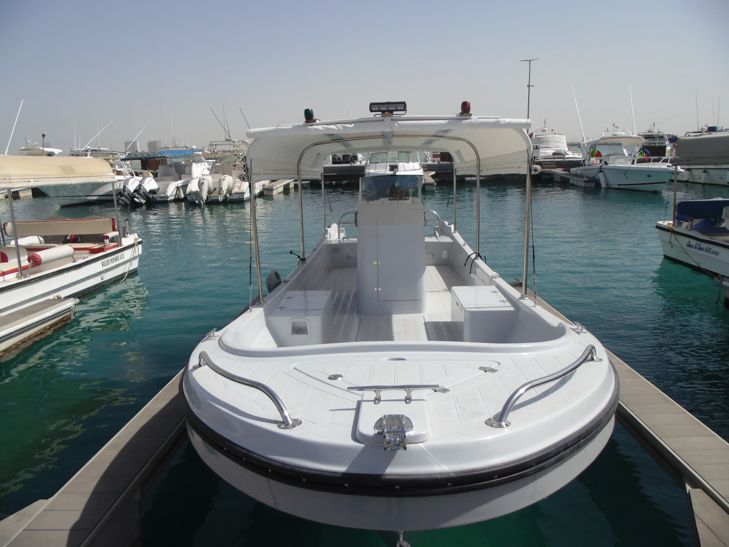 The 9.85 metre boat bow on at the marina, white hull with the canopy up.